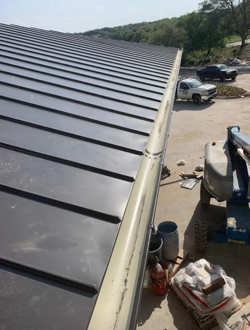 Standing seam panel and gutter detail on a metal roofing jobsite in Headland